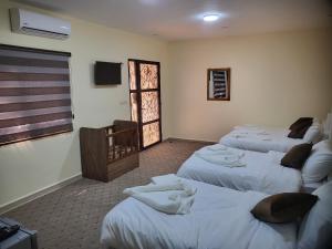 瓦迪穆萨Petra Hill的一间设有三张床的客房,备有毛巾
