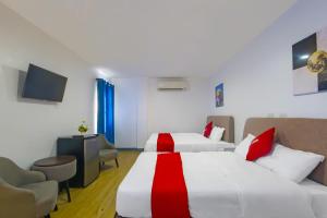 马尼拉OYO 937 Loveness Apartelle的一间酒店客房,设有两张床和电视