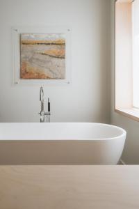 图德拉Hotel Santa Ana Tudela的配有白色浴缸的带绘画的浴室