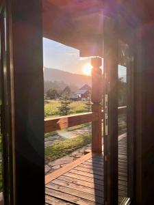 米库利钦Chalet PidStromom的通往阳台的开放式门,阳台享有日落美景