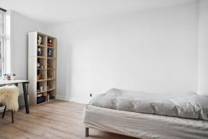 奥尔堡Lejlighed i hjertet af Aalborg的一间卧室配有一张床、一张桌子和一张桌子
