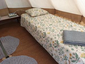 LaitilaGlamping Kiveinen的帐篷内的一张床位,配有毯子和枕头