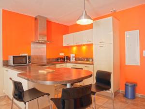 勒帕莱Appartement Le Palais, 2 pièces, 3 personnes - FR-1-418-95的厨房拥有橙色的墙壁和桌椅