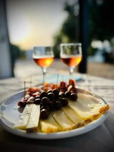 多尔加利Agriturismo La Croisette的一块奶酪和水果,配上两杯葡萄酒