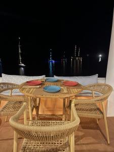 利普西岛Lipsi Blue Hotel的一张木桌,上面有四盘椅子