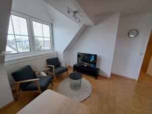 Flataid Apartments Gössendorf/Magna的客厅配有2把椅子和平面电视