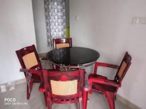 AnachalMunnar Hills & Mist View的一张桌子和四把红色椅子