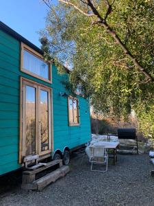 圣马丁德洛斯Hermosa Tiny House con Vista al Chapelco的蓝色的小房子前面有一张桌子