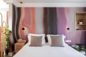 索非亚Oborishte 63,The Art Boutique Hotel by Sandglass的卧室配有白色床和色彩缤纷的墙壁