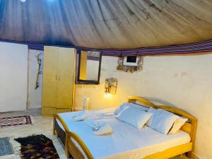 瓦迪穆萨Pink city cottage的卧室配有一张带白色床单和枕头的大床。