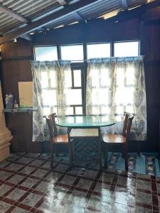 丰盛港Warisan Homestay Anjung的窗户间里的桌椅