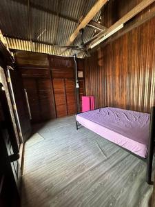 丰盛港Warisan Homestay Anjung的小房间设有床和木墙