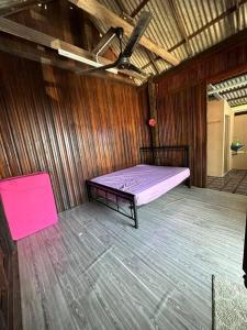 丰盛港Warisan Homestay Anjung的木制客房内的一间卧室,配有一张床