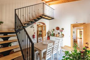 博利凯梅Villa Rodrigues的厨房以及带木桌和楼梯的用餐室。