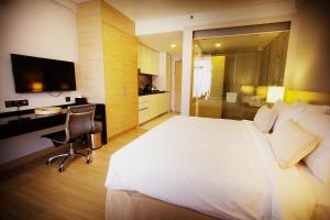 马六甲海峡套房酒店的酒店客房设有一张白色大床和一张书桌