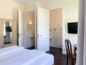 林德拉尔2T Hotel artgenossen的一间白色卧室,配有两张床和一间浴室