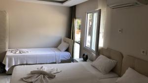 GâvurağılıLikya Inn - Dodurga&Patara Evleri的客房设有两张床和窗户。