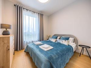 格但斯克Hello Apartments RIO with private parking的一间卧室配有一张带蓝色毯子的床和窗户。