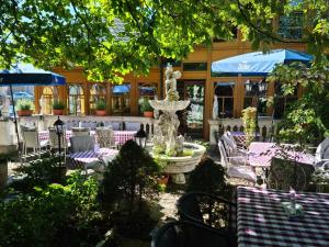 Attnang-Puchheim宏可尼尔广场酒店的喷泉位于餐厅前,餐厅内设有桌椅