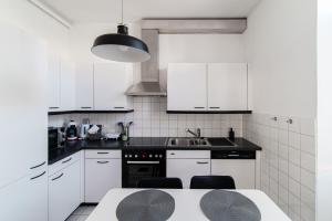 MassagnoGiuka Apartment by Quokka 360 - close to the station的白色的厨房配有白色的橱柜和桌子
