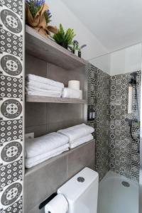 阿尔么丽亚Casa Moreda的一间带卫生间和架子毛巾的浴室