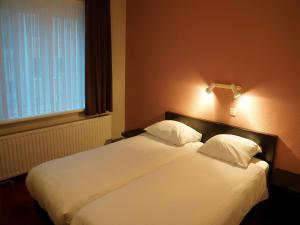 克诺克－海斯特Hotel Du Soleil的卧室配有一张带两个枕头的大白色床