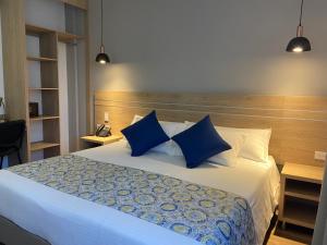 麦德林EcoHub Hotel Medellin的一间卧室配有一张带蓝色枕头的大床