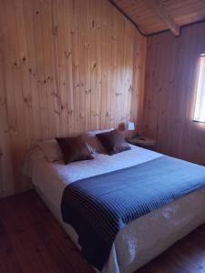 库雷尼佩EKILIBRE Surf Eco Hostal的卧室配有木墙内的一张床