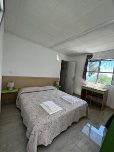 马蒂纳塔圣米歇尔宾馆的一间卧室设有一张大床和一个窗户。