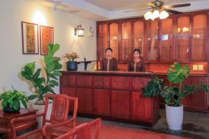 万象Phongsavath Boutique Hotel的两个女人站在一间有植物的房间的酒吧里