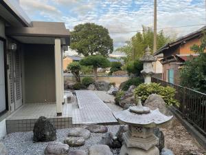 Taga貸別荘せせらぎ的一座花园,房子前方有一个石头喷泉