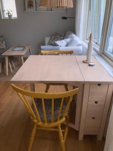 哥德堡Tiny grey house with loft, 15 min from city center的厨房配有桌子、椅子和沙发