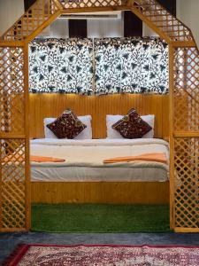 斯利那加ARISTOTLE GROUP OF HOUSEBOATS & TRANSPORTATION的一间卧室配有一张带木篷的床