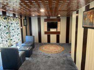 斯利那加ARISTOTLE GROUP OF HOUSEBOATS & TRANSPORTATION的带沙发和电视的客厅
