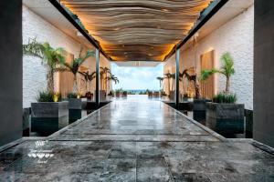 普拉亚卡门Secrets Moxché Playa del Carmen - Adults Only - All Inclusive的楼内长长的走廊,有棕榈树