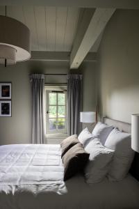 圣艾米隆Hotel Porte Brunet的卧室配有一张大白色床和窗户