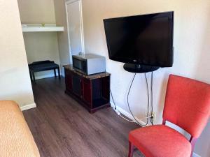 海波因特High Point Arcadia Inn的客厅配有平面电视和红色椅子。