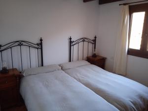 Las RosasCasa Ben Abora的一间卧室配有一张带白色床单的床和一扇窗户。