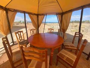 TongGuest house "U apashki"的帐篷内的木桌和椅子