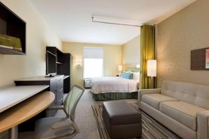 WetheringtonHome2 Suites by Hilton Cincinnati Liberty Township的酒店客房设有床和客厅。