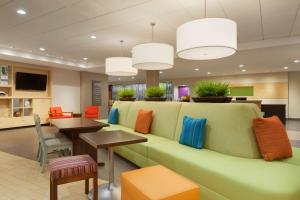 埃尔帕索埃尔帕索机场希尔顿欣庭套房酒店的一间设有绿色沙发和桌子的等候室