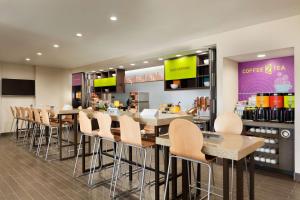 埃尔帕索埃尔帕索机场希尔顿欣庭套房酒店的餐厅设有酒吧,配有桌椅