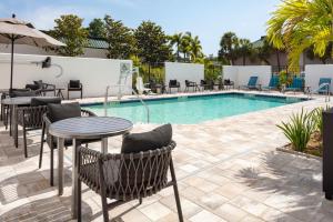 克利尔沃特TownePlace Suites by Marriott Tampa Clearwater的露台旁的游泳池配有桌椅