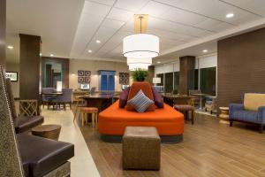钱德勒凤凰城钱德勒希尔顿欣庭套房酒店的中间设有橙色椅子的办公室大堂