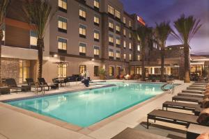 坦培Hilton Garden Inn Phoenix-Tempe University Research Park, Az的酒店游泳池设有椅子,酒店