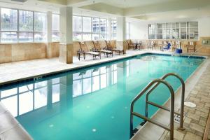 萨凡纳萨凡纳/市中心汉普顿酒店兼套房的一个带桌椅的大型游泳池