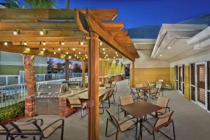 代托纳海滩希尔顿惠庭套房酒店 - 戴托纳海滩快道-机场的一个带桌椅和烧烤设施的庭院