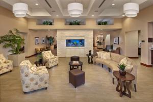代托纳海滩希尔顿惠庭套房酒店 - 戴托纳海滩快道-机场的大堂配有沙发、椅子和壁炉
