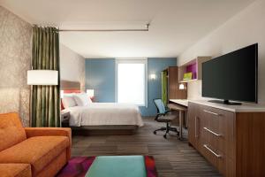 银泉Home2 Suites By Hilton Silver Spring的配有一张床和一台平面电视的酒店客房