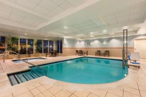 阿什本杜勒斯北希尔顿花园旅馆的一座配有桌椅的酒店游泳池
